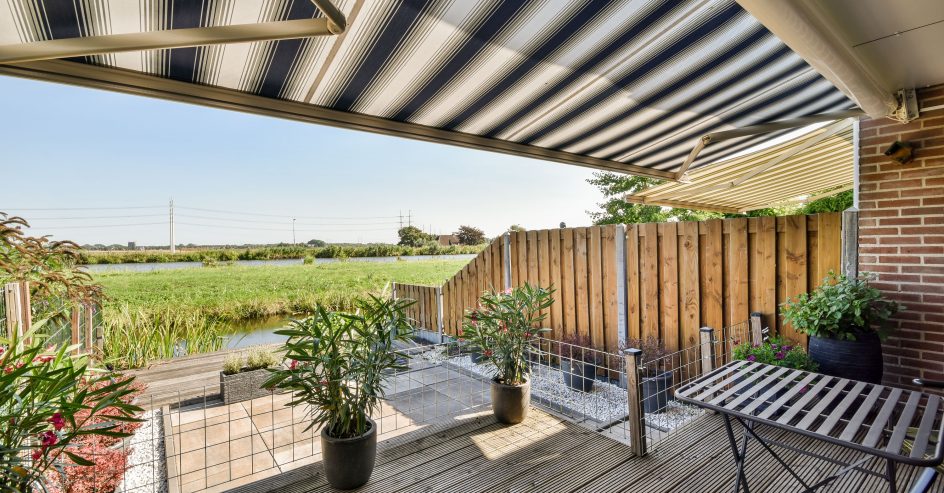 Neat paved patio with sitting area and small garden near wooden fence