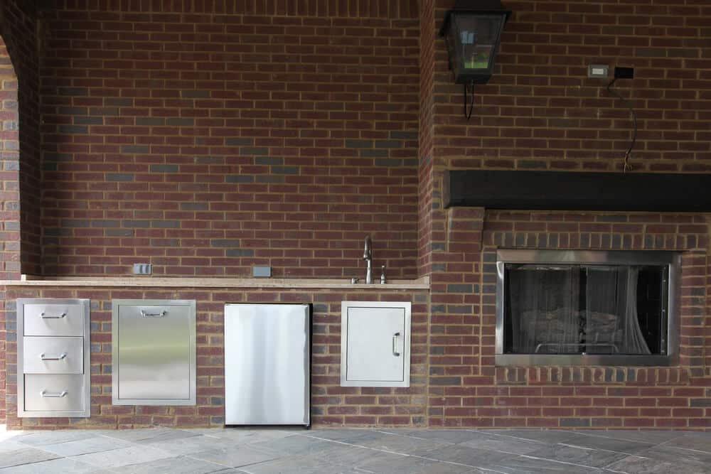 Outdoor kitchen and patio featuring a fire feature for year-round comfort