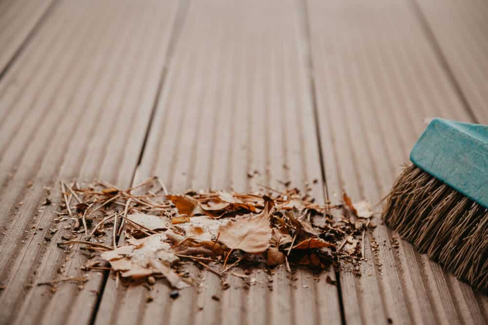 Fallen leaves on a patio floor that need clearing during seasonal gazebo maintenance